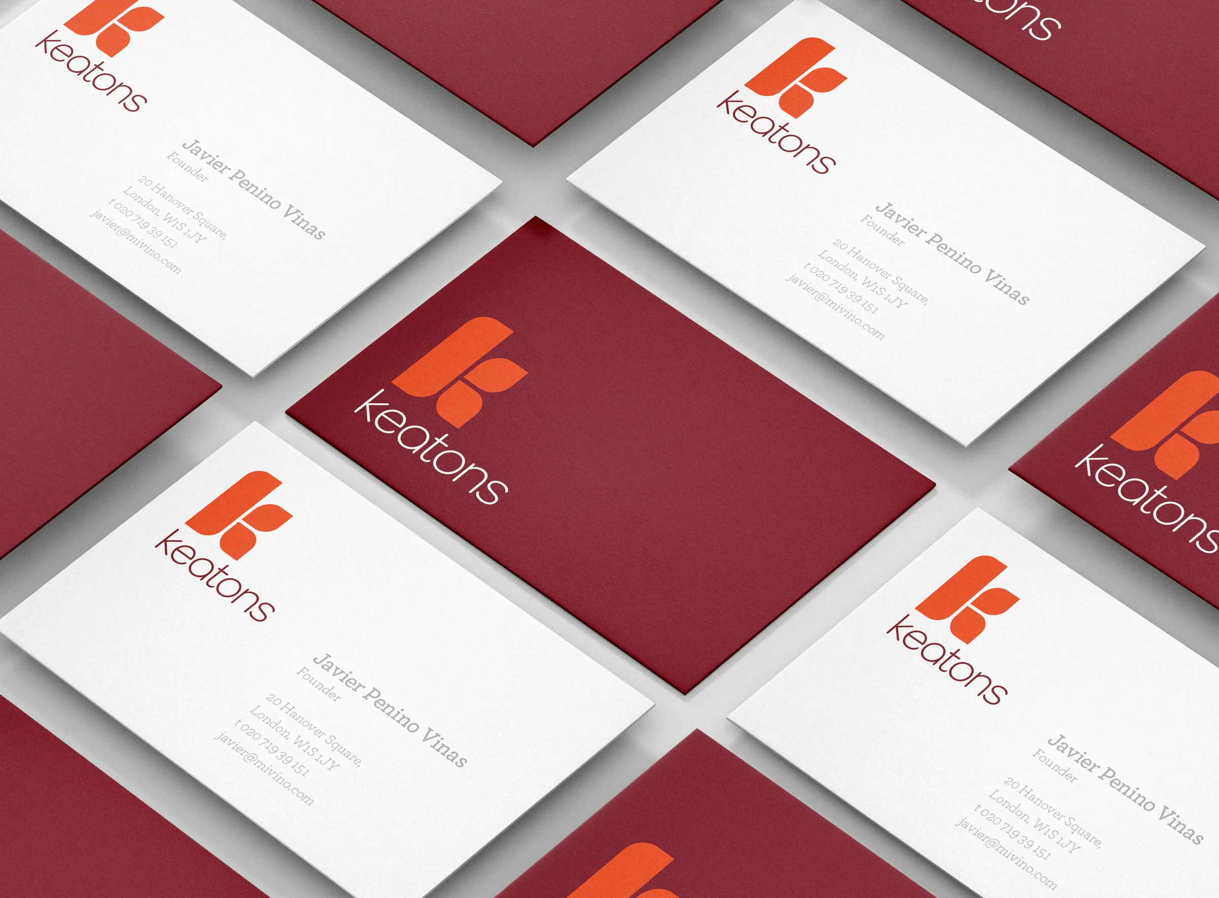 Rows of alternating burgundy and white Keatons business cards laid out on a diagonal grid