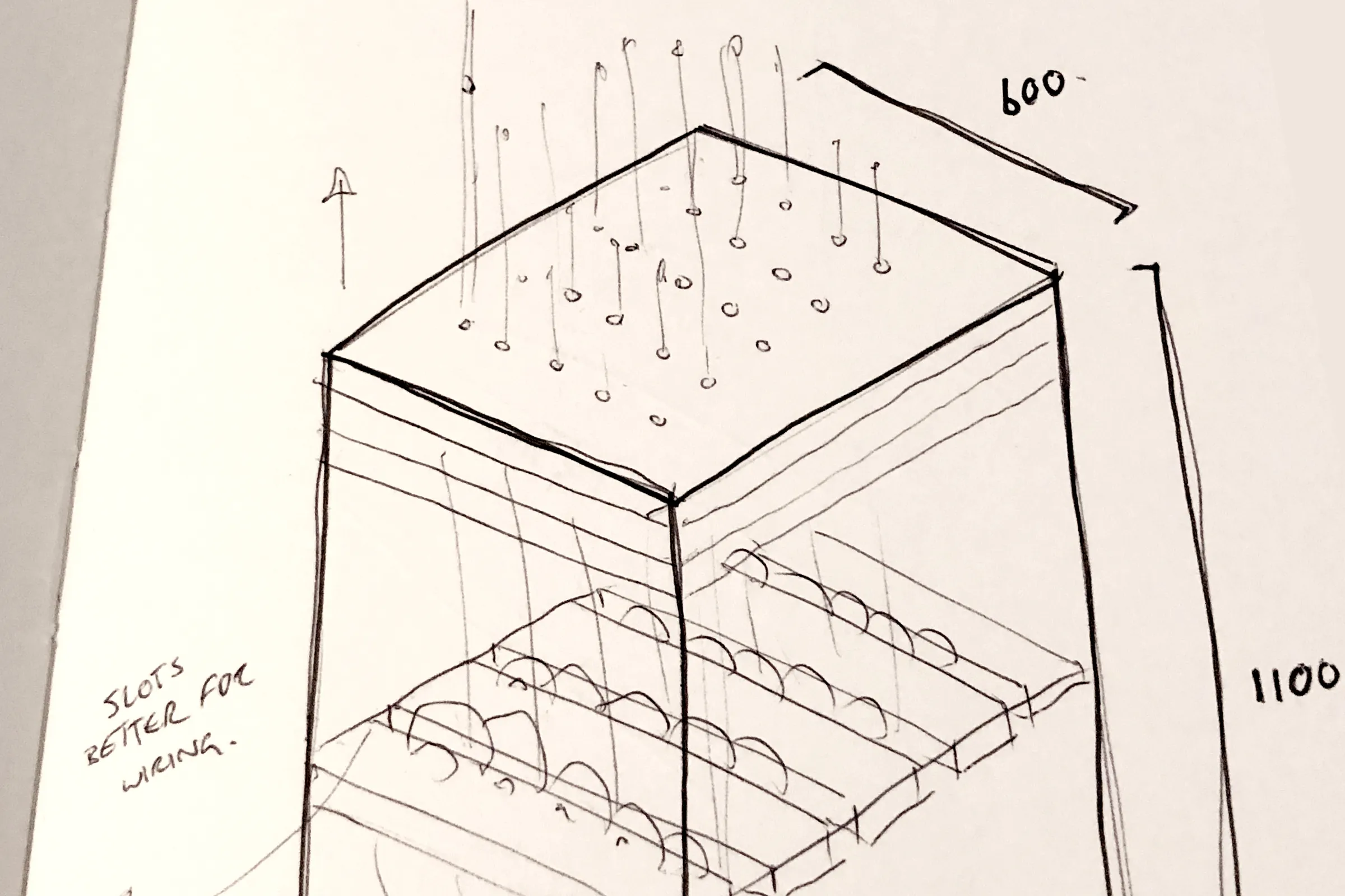 Sketch of a cabinet about 600 wide and 1100 tall, with pins on top, rows of discs on slotted shelves below, and a note reading slots better for wiring