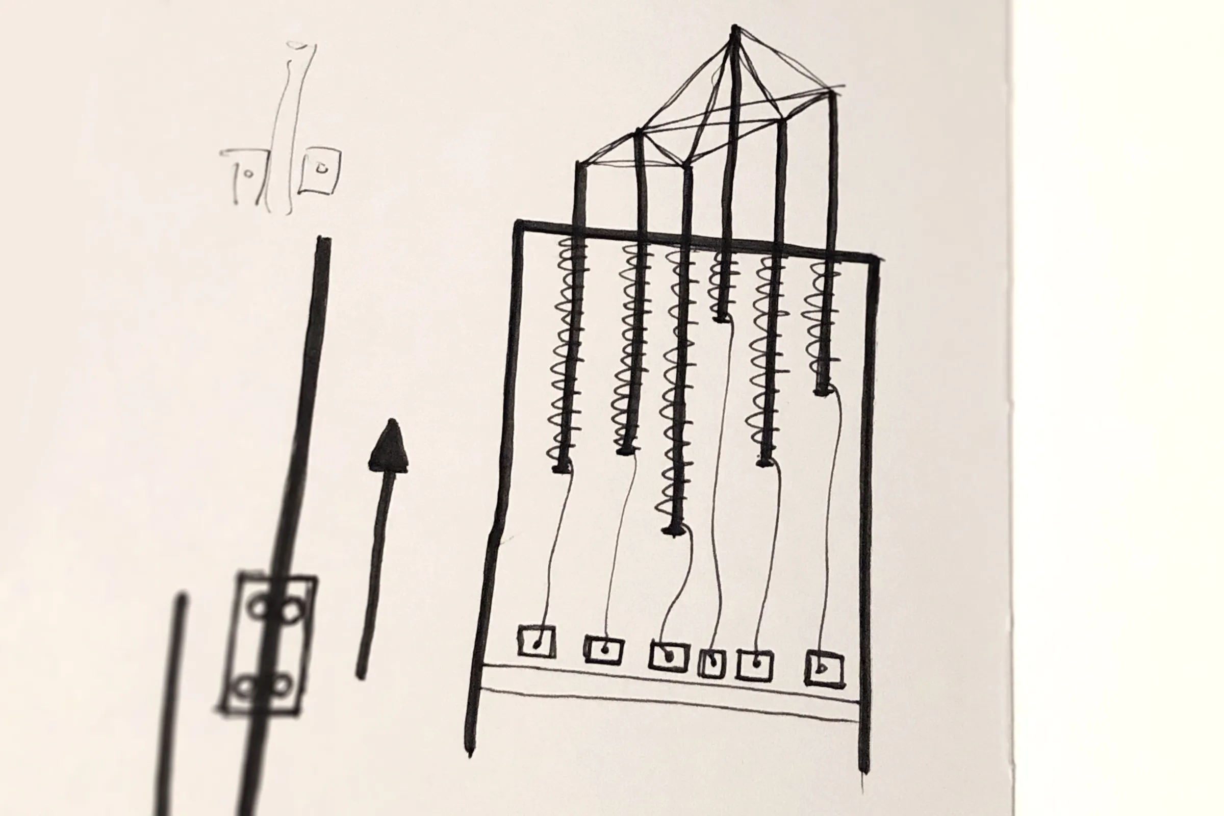 Sketch of pins lifted by threads running down to a row of motors, with an arrow showing the upward movement