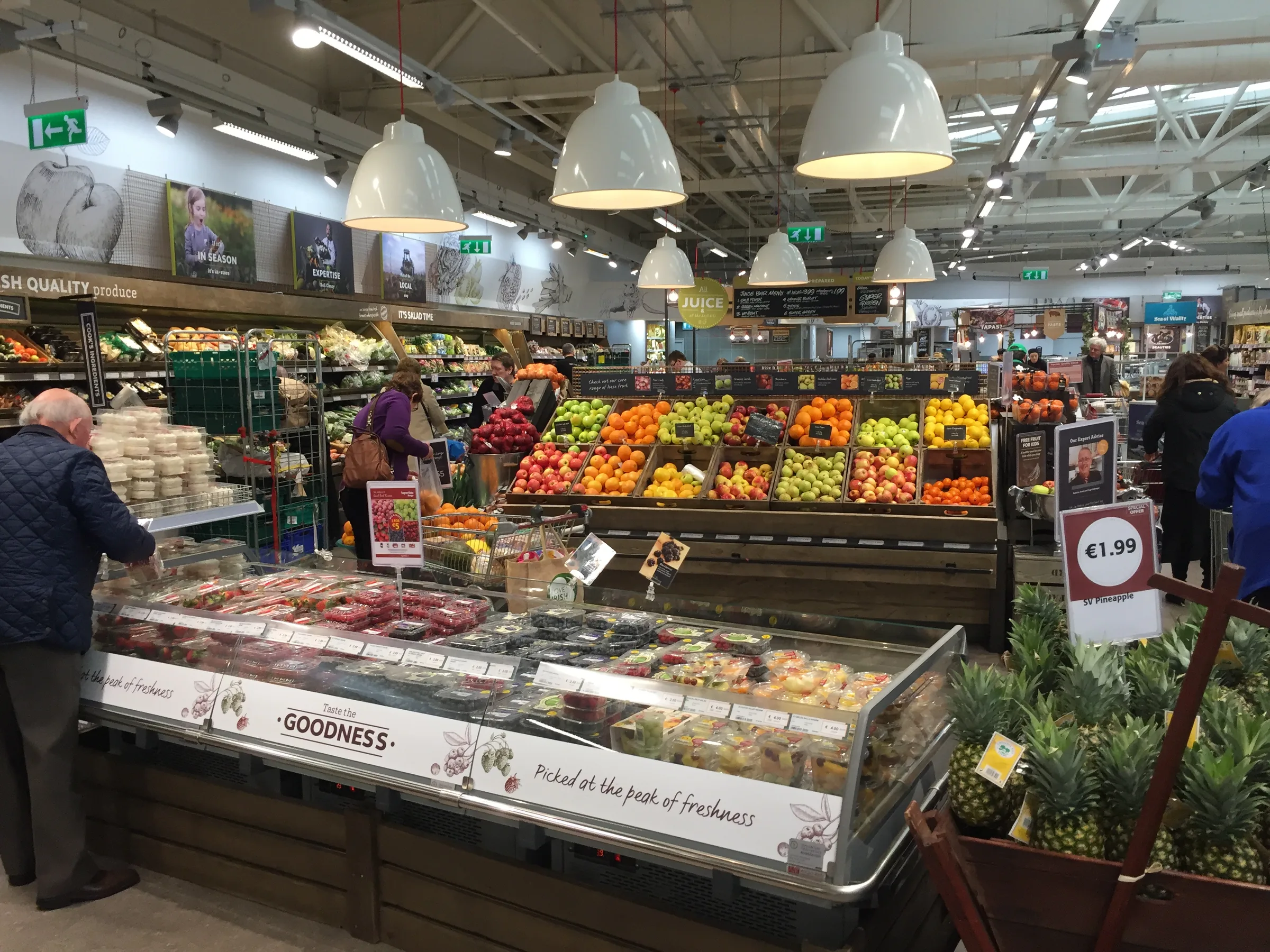 A SuperValu store with a bakery table in the foreground and a fresh produce area stretching behind it